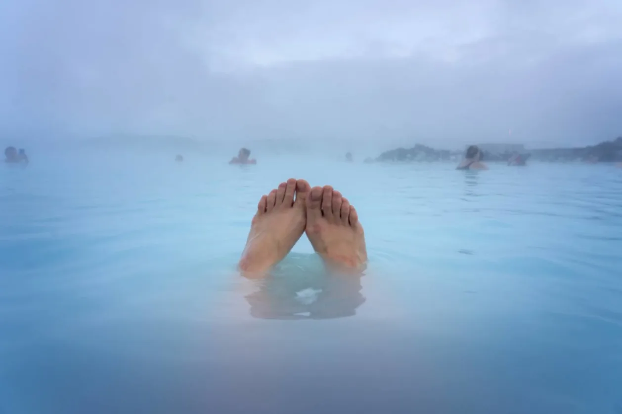 woman's feet in blue lagoon public baths reykjavik